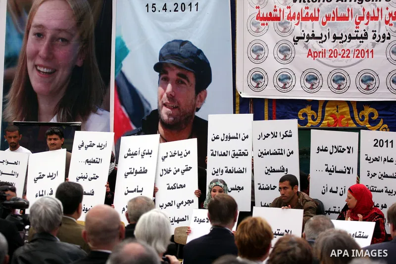 Palestinians hold up slogans during the opening ceremony of the 6th Bilin international conference for Palestinian Popular Resistance on April 20, 2011 in West Bank village of Bilin, near Ramallah. Fayyad called on the i...