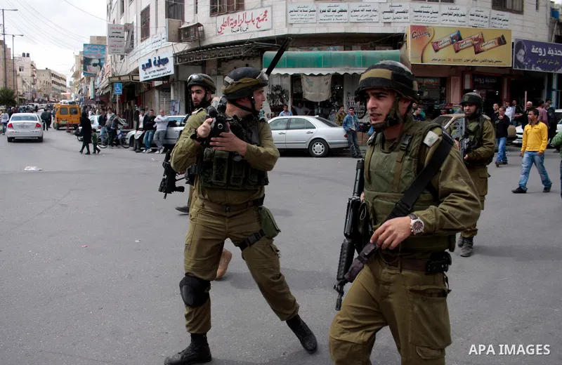 Israeli soldiers stand guard in an empty street in Hebron in the occupied West Bank on April 20, 2011. The Israeli army imposed a temporary curfew on Palestinians in the city centre to allow Jewish settlers to visit the...