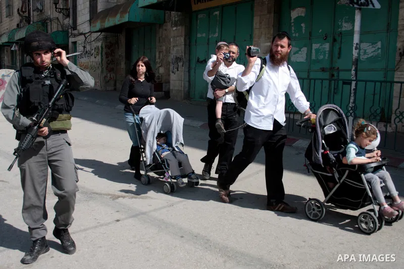 Israeli soldiers stand guard in an empty street in Hebron in the occupied West Bank on April 20, 2011. The Israeli army imposed a temporary curfew on Palestinians in the city centre to allow Jewish settlers to visit the...