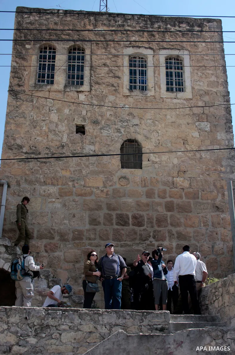 Israeli settlers walk in an empty street in Hebron in the occupied West Bank on April 20, 2011.The Israeli army imposed a temporary curfew on Palestinians in the city centre to allow Jewish settlers to visit the tomb of...
