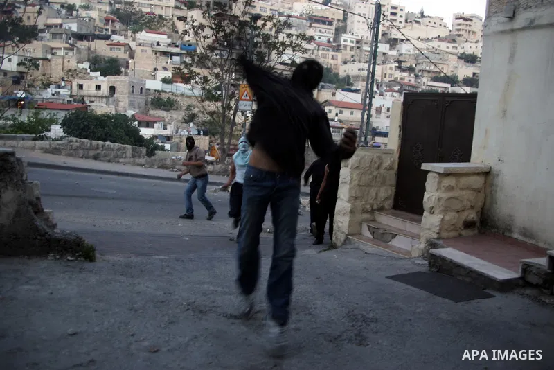 Palestinian youths hurl stones toward Israeli soldiers during the clashes in the Jerusalem neighbourhood of Silwan on April 20,2011. Photo by Mahfouz Abu Turk
