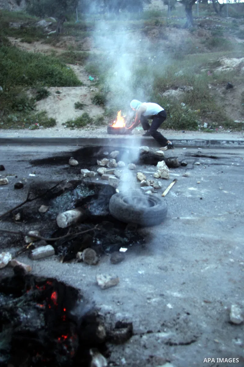 Palestinian youths set tyres ablaze during the clashes with Israeli soldiers in the Jerusalem neighbourhood of Silwan on April 20,2011. Photo by Mahfouz Abu Turk