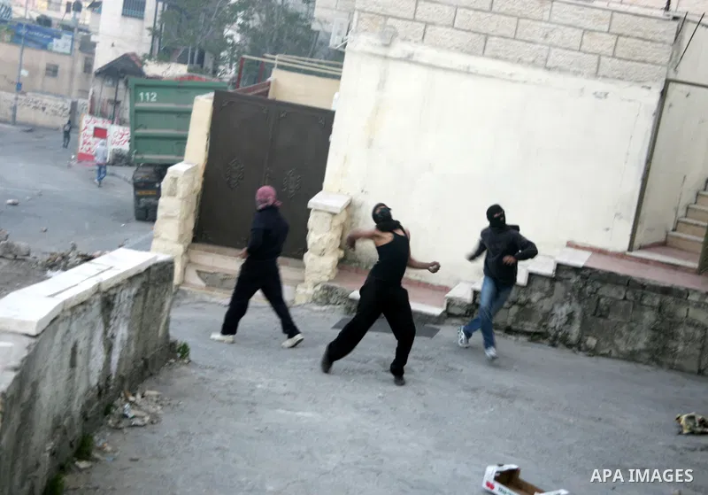 Palestinian youths hurl stones toward Israeli soldiers during the clashes in the Jerusalem neighbourhood of Silwan on April 20,2011. Photo by Mahfouz Abu Turk