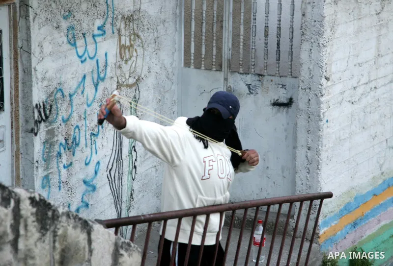 Palestinian youths hurl stones toward Israeli soldiers during the clashes in the Jerusalem neighbourhood of Silwan on April 20,2011. Photo by Mahfouz Abu Turk