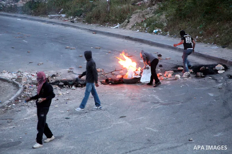 Palestinian youths set tyres ablaze during the clashes with Israeli soldiers in the Jerusalem neighbourhood of Silwan on April 20,2011. Photo by Sliman Khader