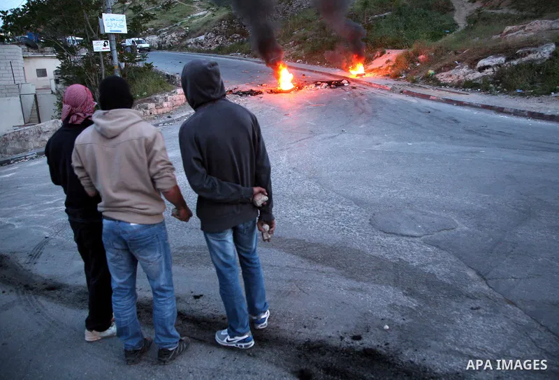 Palestinian youths set tyres ablaze during the clashes with Israeli soldiers in the Jerusalem neighbourhood of Silwan on April 20,2011. Photo by Sliman Khader