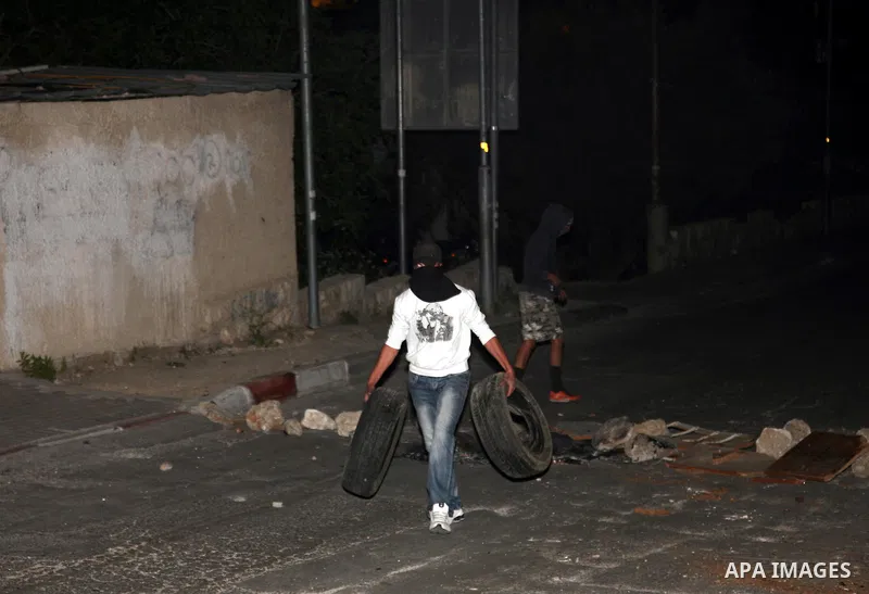 Palestinian youths set tyres ablaze during the clashes with Israeli soldiers in the Jerusalem neighbourhood of Silwan on April 20,2011. Photo by Sliman Khader