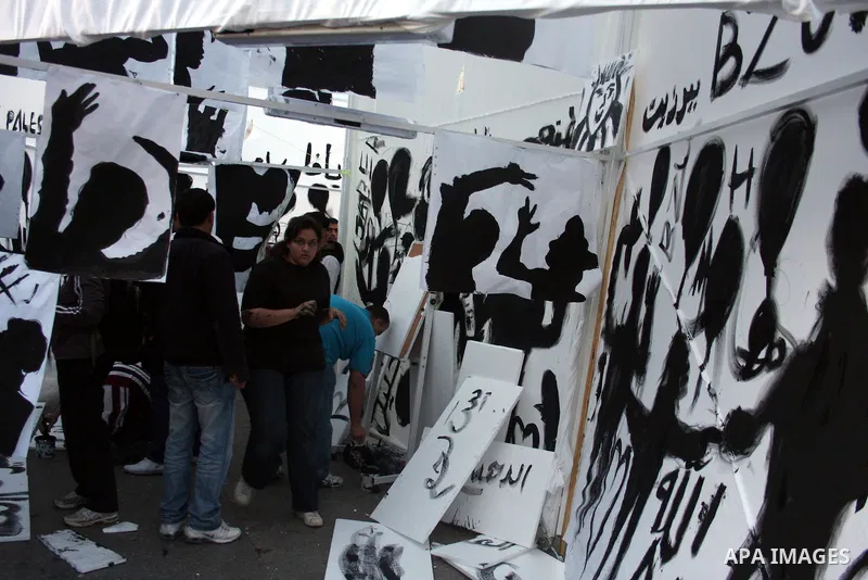 Palestinians participate in exhibition organized by students from Birzeit University in the West Bank city of Ramallah on April 20,2011, in cooperation with Belgium's Lacambre University. The exhibition was erected in th...