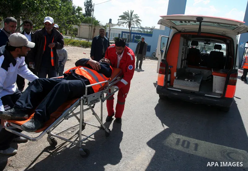 Palestinians wheel an injured worker after a tank fired shots toward him in the eastern Gaza city on April 22,2011. Three Palestinians were lightly to moderately wounded when a tank fired at a group of people near the Ka...