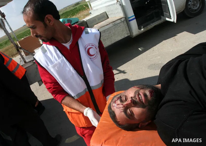 Palestinians wheel an injured worker after a tank fired shots toward him in the eastern Gaza city on April 22,2011. Three Palestinians were lightly to moderately wounded when a tank fired at a group of people near the Ka...