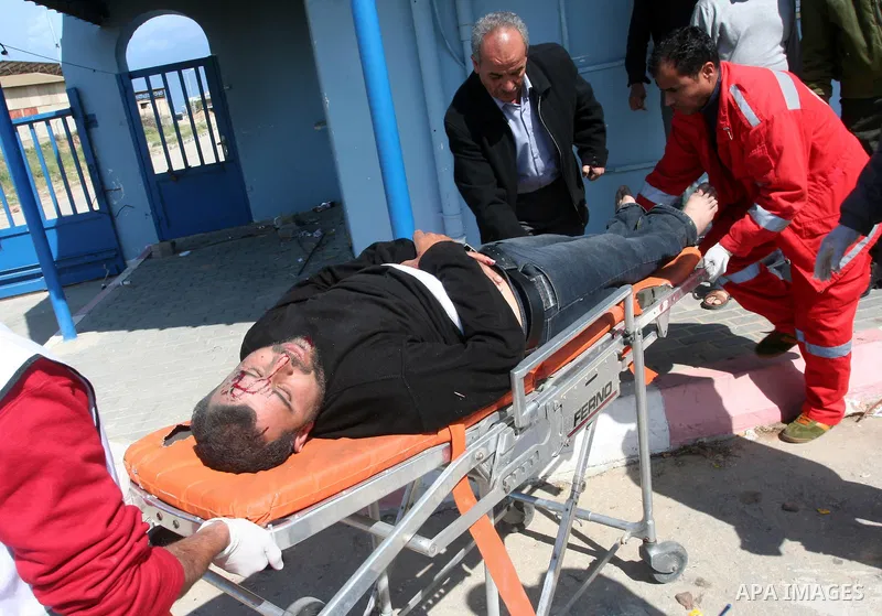 Palestinians wheel an injured worker after a tank fired shots toward him in the eastern Gaza city on April 22,2011. Three Palestinians were lightly to moderately wounded when a tank fired at a group of people near the Ka...