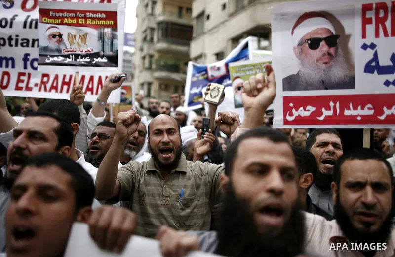 Supporters of Egyptian cleric Sheikh Omar Abdel Rahman hold banners as they demonstrate to call for his release in front of the U.S. embassy in Cairo on April 21, 2011. Abdel-Rahman, was jailed for life in January 1996 f...