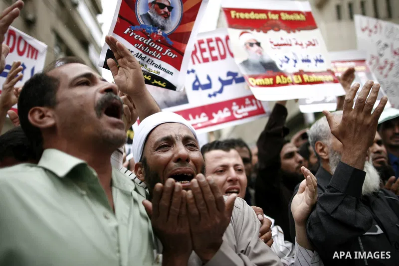 Supporters of Egyptian cleric Sheikh Omar Abdel Rahman hold banners as they demonstrate to call for his release in front of the U.S. embassy in Cairo on April 21, 2011. Abdel-Rahman, was jailed for life in January 1996 f...