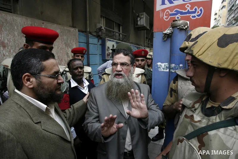 Abbud al-Zomor (C), a member of Egypt's Islamic Jihad who was jailed over the 1981 assassination of president Anwar Sadat, stands next to soldiers during a demonstration to call for the release of Egyptian cleric Sheikh...