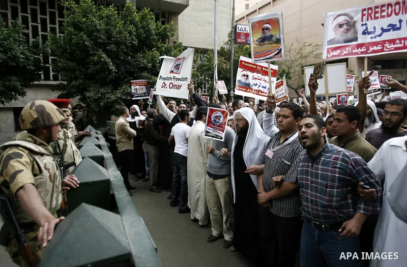 Supporters of Egyptian cleric Sheikh Omar Abdel Rahman hold banners as they demonstrate to call for his release in front of the U.S. embassy in Cairo on April 21, 2011. Abdel-Rahman, was jailed for life in January 1996 f...