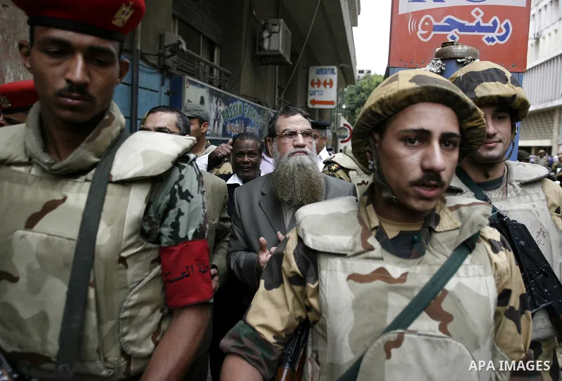 Abbud al-Zomor (C), a member of Egypt's Islamic Jihad who was jailed over the 1981 assassination of president Anwar Sadat, stands next to soldiers during a demonstration to call for the release of Egyptian cleric Sheikh...