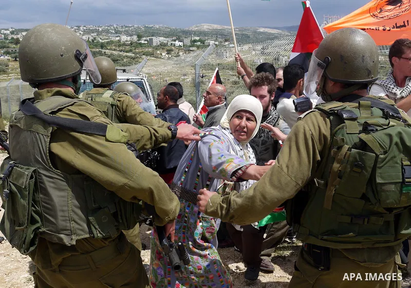Israeli soldiers scuffle with Palestinian and foreign protesters during the weekly demonstration against Israel's controversial separation barrier in the village of Bilin, near the West Bank city of Ramallah on April 22,...