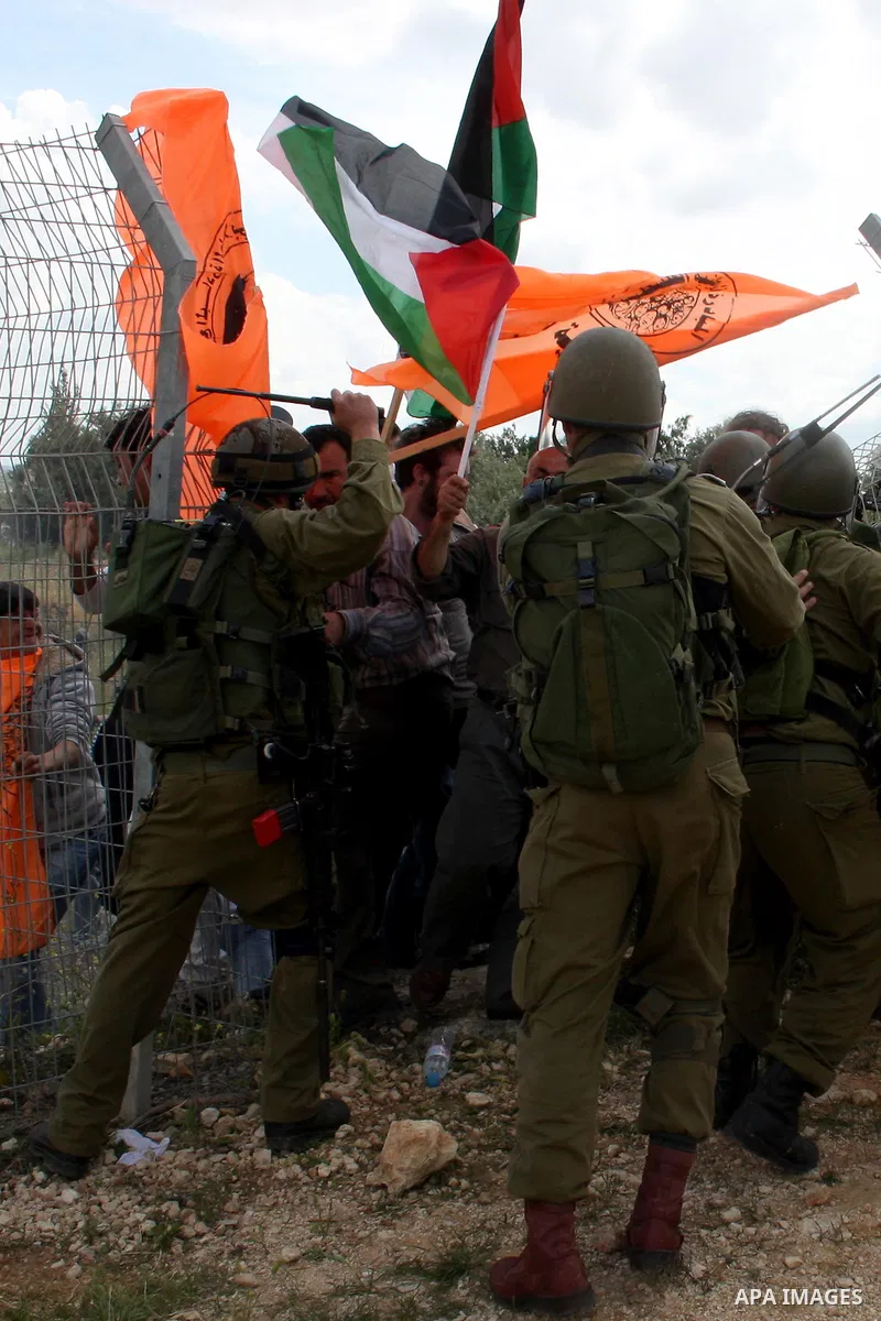 Israeli soldiers scuffle with Palestinian and foreign protesters during the weekly demonstration against Israel's controversial separation barrier in the village of Bilin, near the West Bank city of Ramallah on April 22,...