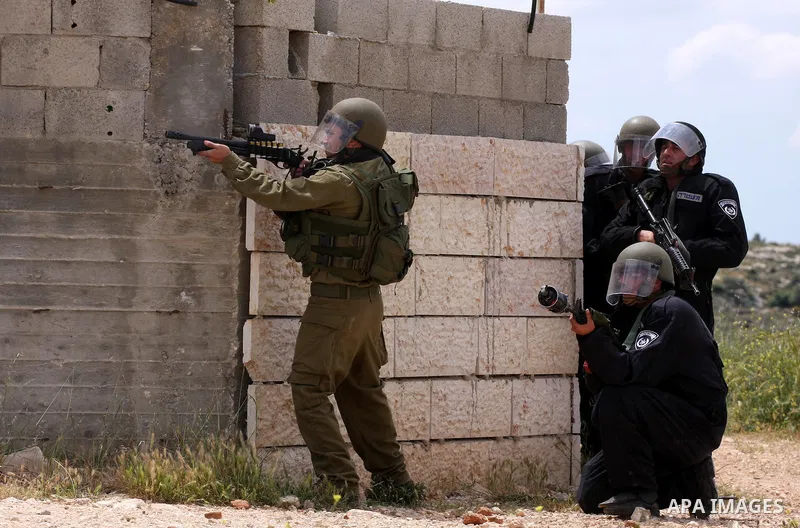 Israeli soldiers fire tear gas canisters toward protesters during the weekly demonstration against Israel's controversial separation barrier in the village of Bilin, near the West Bank city of Ramallah on April 22, 2011....
