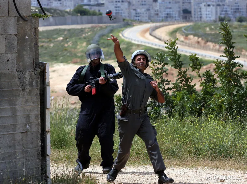 Israeli soldiers fire tear gas canisters toward protesters during the weekly demonstration against Israel's controversial separation barrier in the village of Bilin, near the West Bank city of Ramallah on April 22, 2011....