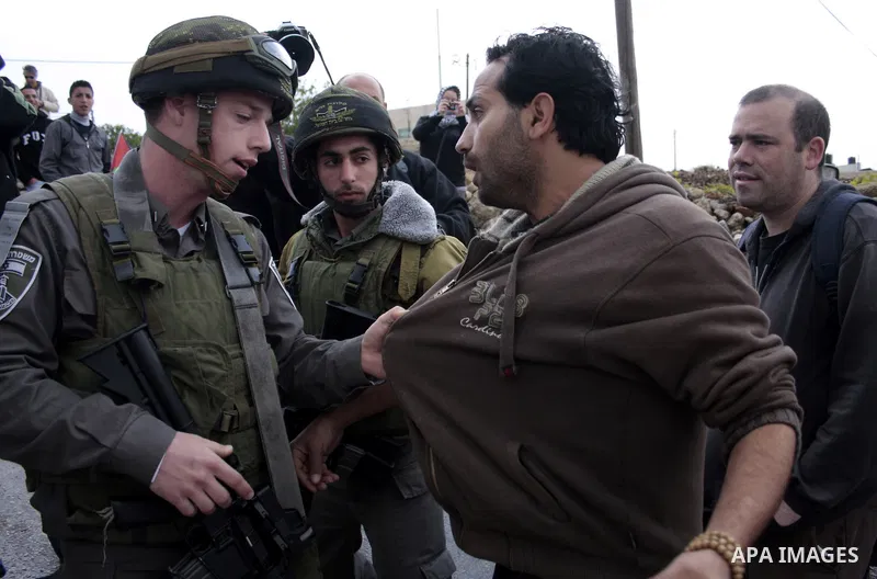 Protesters argue with an Israeli soldier during a demonstration against Israel's controversial separation barrier in the West Bank village of Maasarah, near the biblical town of Bethlehem on April 22, 2011.Israel says th...