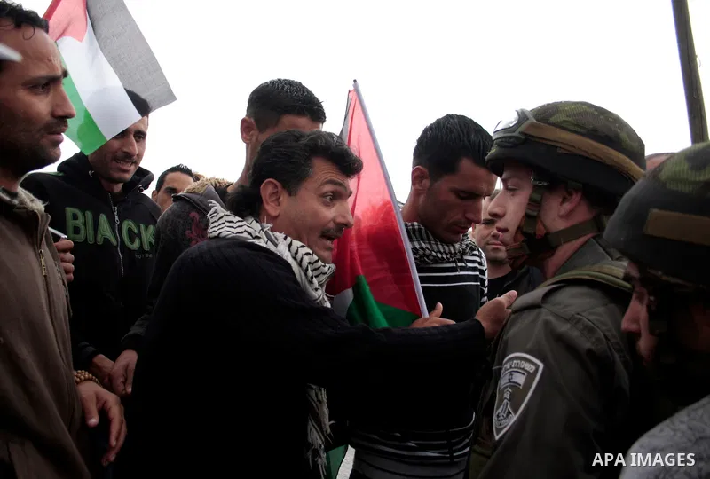 Protesters argue with an Israeli soldier during a demonstration against Israel's controversial separation barrier in the West Bank village of Maasarah, near the biblical town of Bethlehem on April 22, 2011.Israel says th...