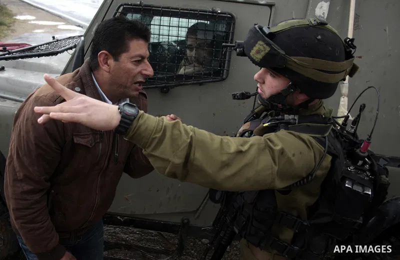 Protesters argue with an Israeli soldier during a demonstration against Israel's controversial separation barrier in the West Bank village of Maasarah, near the biblical town of Bethlehem on April 22, 2011.Israel says th...