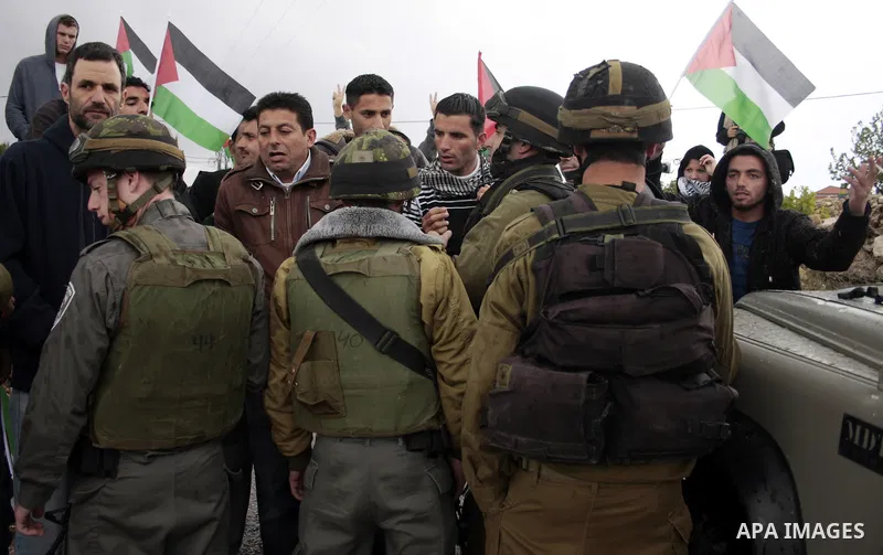 Protesters argue with an Israeli soldier during a demonstration against Israel's controversial separation barrier in the West Bank village of Maasarah, near the biblical town of Bethlehem on April 22, 2011.Israel says th...