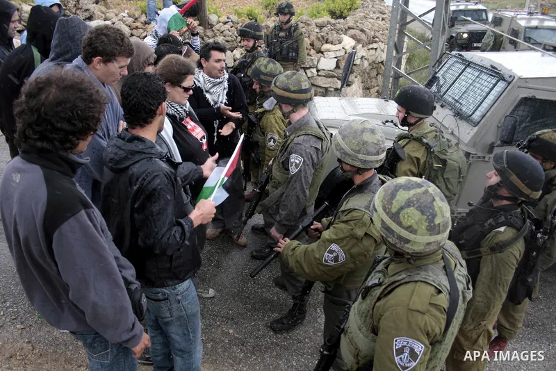 Protesters argue with an Israeli soldier during a demonstration against Israel's controversial separation barrier in the West Bank village of Maasarah, near the biblical town of Bethlehem on April 22, 2011.Israel says th...
