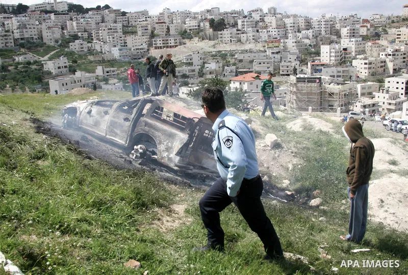 Israeli soldiers stand guard near a burnt Israeli army vehicle on April 22, 2011 after it flipped over and was set alight by Palestinian youths in the flashpoint neighbourhood of Issawiya in annexed east Jerusalem. No in...