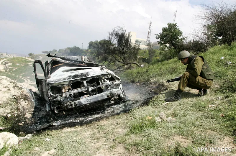 Israeli soldiers stand guard near a burnt Israeli army vehicle on April 22, 2011 after it flipped over and was set alight by Palestinian youths in the flashpoint neighbourhood of Issawiya in annexed east Jerusalem. No in...