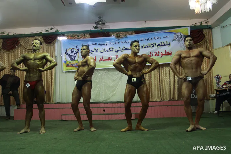Palestinian men take part during competing in a bodybuilding contest at a hall in Gaza city, Friday, April 22, 2011. Many of the men use women's cosmetics, mud, or paint to enhance their muscles. Number of men from aroun...
