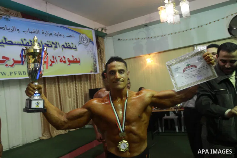 Palestinian men take part during competing in a bodybuilding contest at a hall in Gaza city, Friday, April 22, 2011. Many of the men use women's cosmetics, mud, or paint to enhance their muscles. Number of men from aroun...