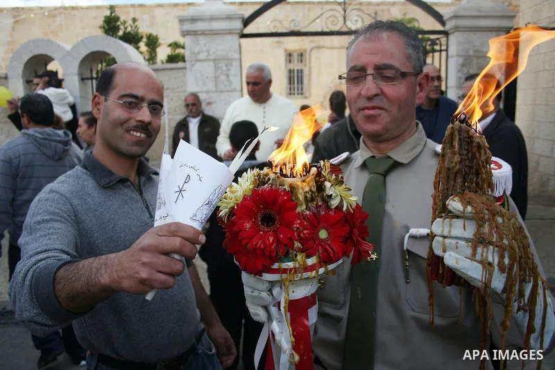 Palestinian Orthodox Christians gather on April 23, 2011, to take part in the 'Holy Fire' parade on the eve of the Orthodox Easter Sunday in the West Bank city of Ramallah in the Israeli occupied West Bank. Photo by Issa...