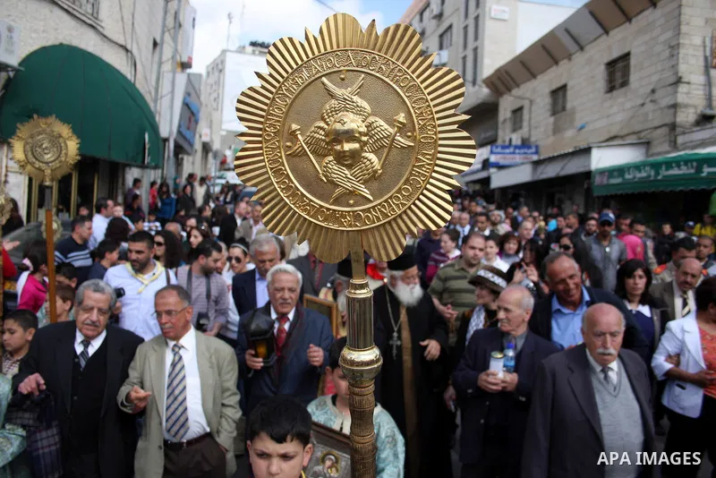 Palestinian Orthodox Christians gather on April 23, 2011, to take part in the 'Holy Fire' parade on the eve of the Orthodox Easter Sunday in the West Bank city of Ramallah in the Israeli occupied West Bank. Photo by Issa...