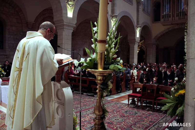 A Catholic priest lights a Paschal candle inside the Church of the Nativity compound at the opening of the Easter Vigil on Holy Saturday late April 23, 2011 in the West Bank town of Bethlehem. Christians of the western c...
