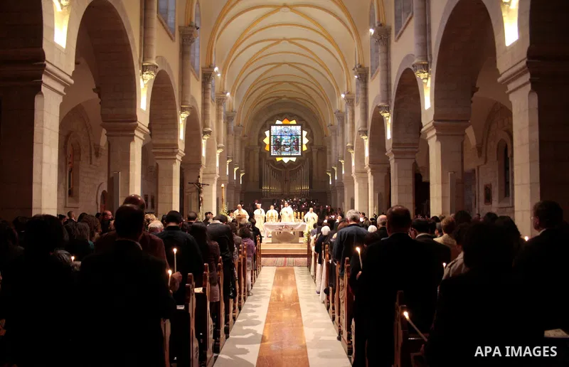 A Catholic priest lights a Paschal candle inside the Church of the Nativity compound at the opening of the Easter Vigil on Holy Saturday late April 23, 2011 in the West Bank town of Bethlehem. Christians of the western c...