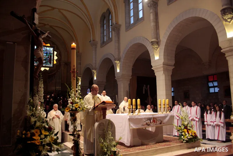 A Catholic priest lights a Paschal candle inside the Church of the Nativity compound at the opening of the Easter Vigil on Holy Saturday late April 23, 2011 in the West Bank town of Bethlehem. Christians of the western c...
