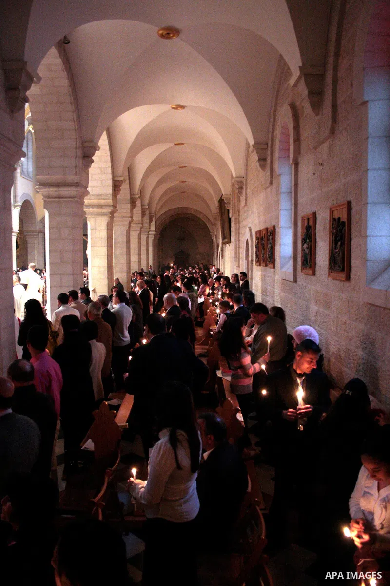 A Catholic priest lights a Paschal candle inside the Church of the Nativity compound at the opening of the Easter Vigil on Holy Saturday late April 23, 2011 in the West Bank town of Bethlehem. Christians of the western c...