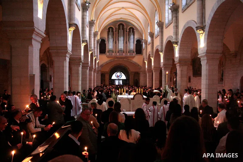 A Catholic priest lights a Paschal candle inside the Church of the Nativity compound at the opening of the Easter Vigil on Holy Saturday late April 23, 2011 in the West Bank town of Bethlehem. Christians of the western c...