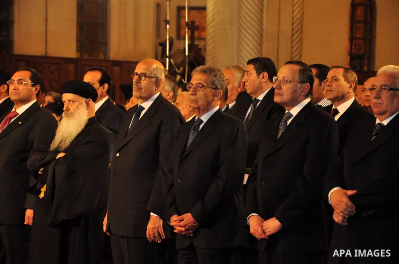 Egypt's presidential candidates Arab League Secretary-General Amr Moussa (R) and Mohamed El Baradei stand next to a priest (L) during a Coptic Christian Easter service at the main cathedral in Cairo April 23, 2011. This...