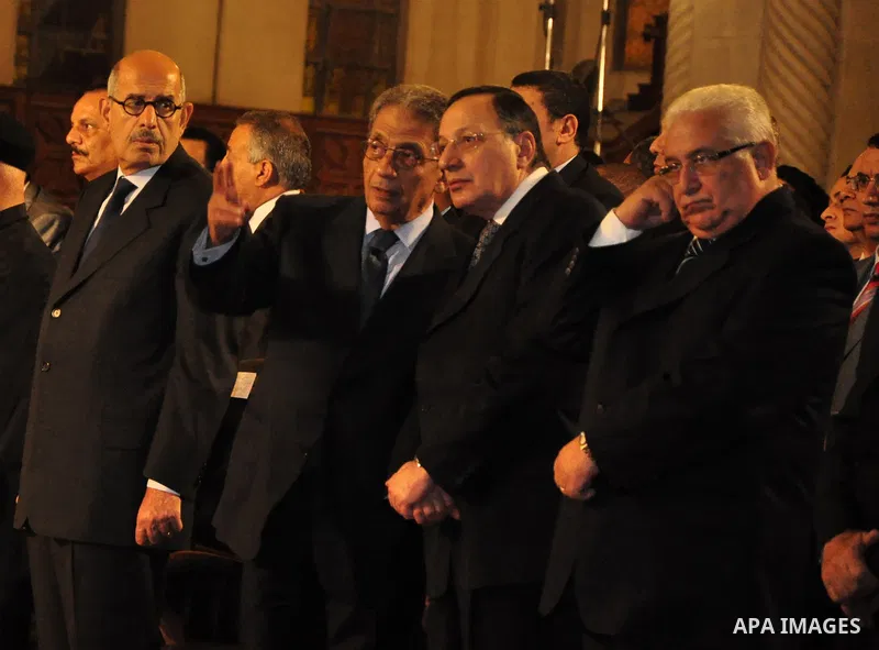 Egypt's presidential candidates Arab League Secretary-General Amr Moussa (R) and Mohamed El Baradei stand next to a priest (L) during a Coptic Christian Easter service at the main cathedral in Cairo April 23, 2011. This...