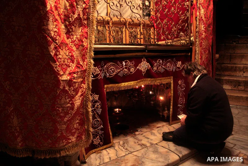 A Christian pilgrim prays in the Grotto, the alleged birthplace of Jesus Christ, in the Church of the Nativity during Sunday mass, April 24 2011.Photo by Najeh Hashlamoun..