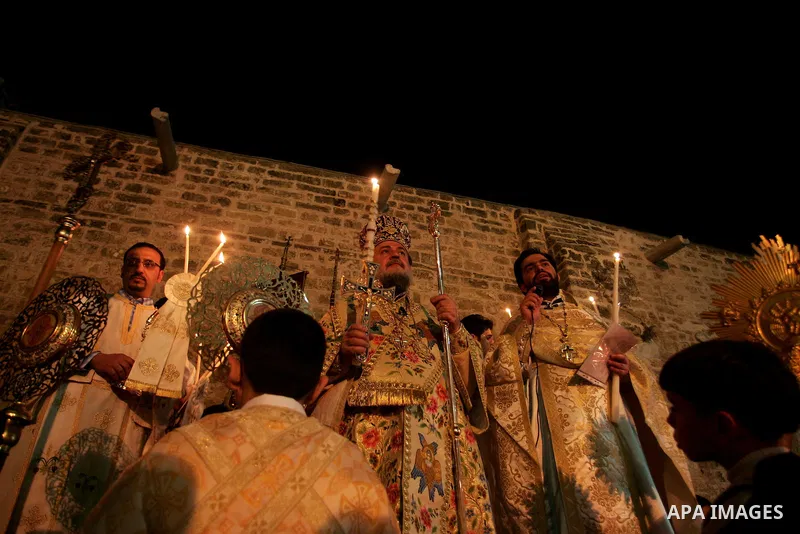Christian Orthodox hold up candles lit from the 'Holy Fire' as thousands gather in the Church in Gaza City on April 24, 2011. Photo by Mohammed Othman