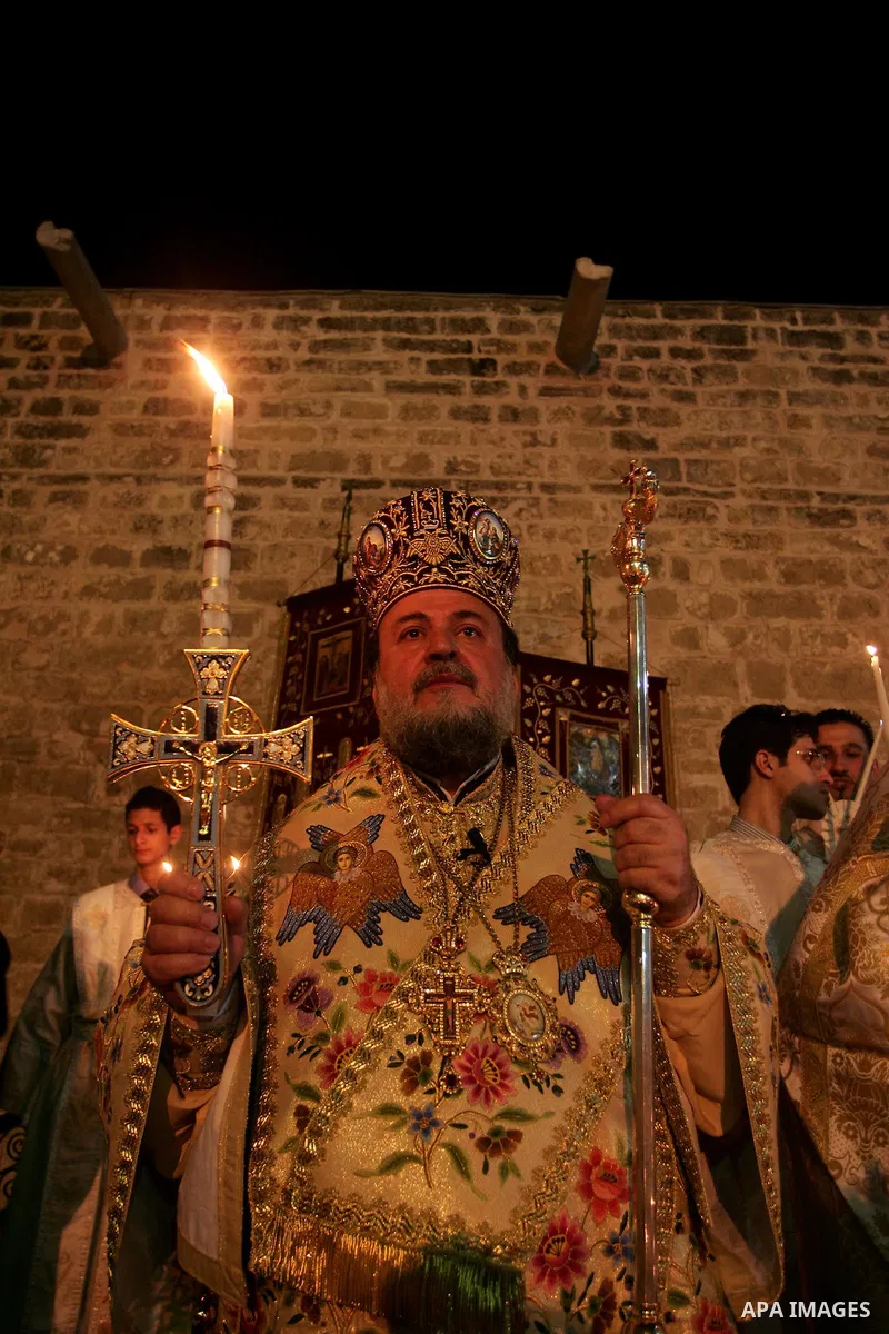 Christian Orthodox hold up candles lit from the 'Holy Fire' as thousands gather in the Church in Gaza City on April 24, 2011. Photo by Mohammed Othman