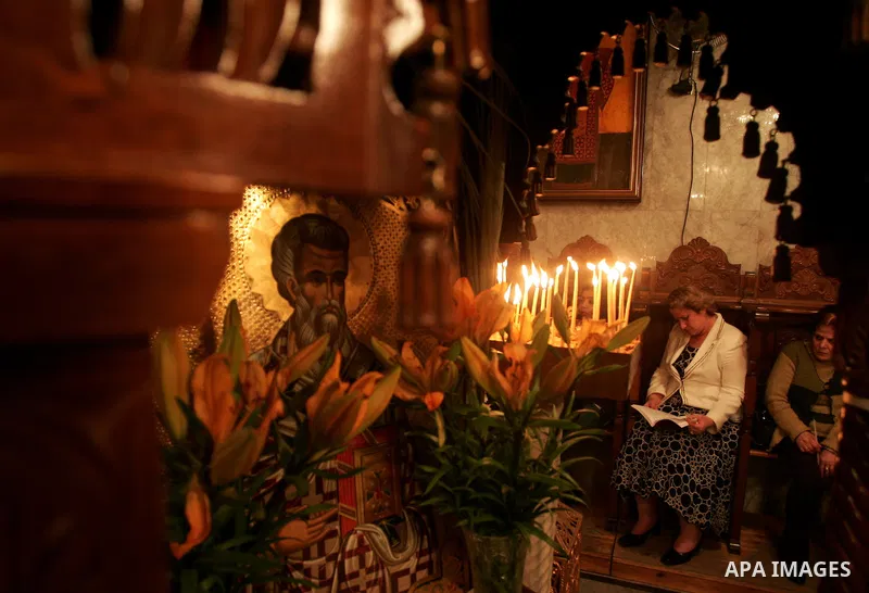 Christian Orthodox hold up candles lit from the 'Holy Fire' as thousands gather in the Church in Gaza City on April 24, 2011. Photo by Mohammed Othman