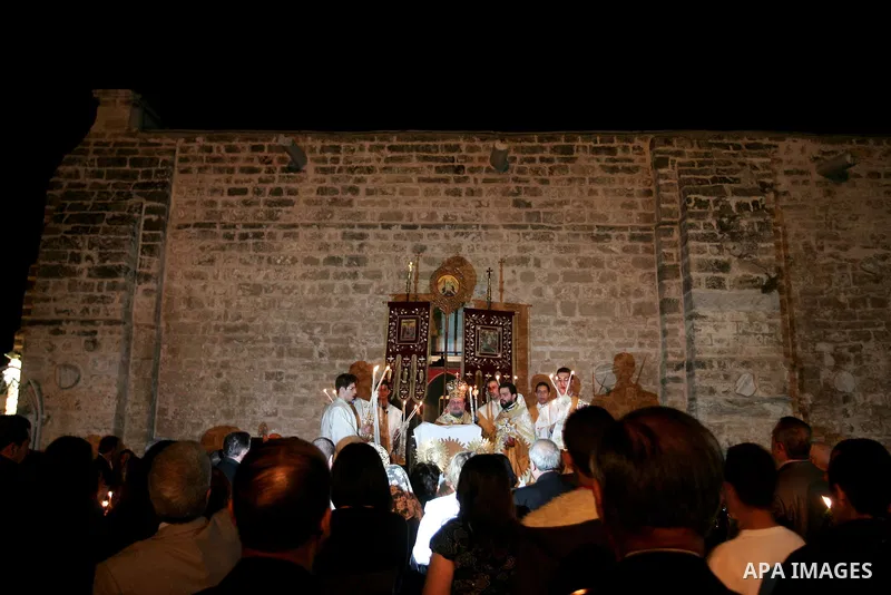 Christian Orthodox hold up candles lit from the 'Holy Fire' as thousands gather in the Church in Gaza City on April 24, 2011. Photo by Mohammed Othman