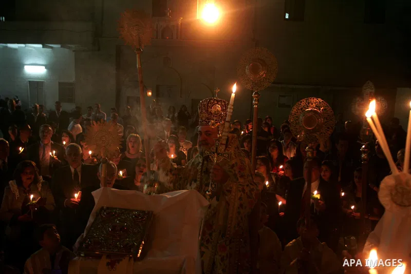 Christian Orthodox hold up candles lit from the 'Holy Fire' as thousands gather in the Church in Gaza City on April 24, 2011. Photo by Mohammed Othman