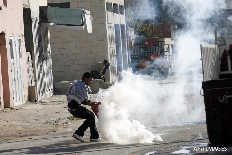 Palestinian youth throw stones towards Israeli soldiers patrolling near the shrine of Joseph's Tomb in the West Bank city of Nablus on April 24, 2011 as clashes erupted after an Israeli worshipper was shot dead by Palest...