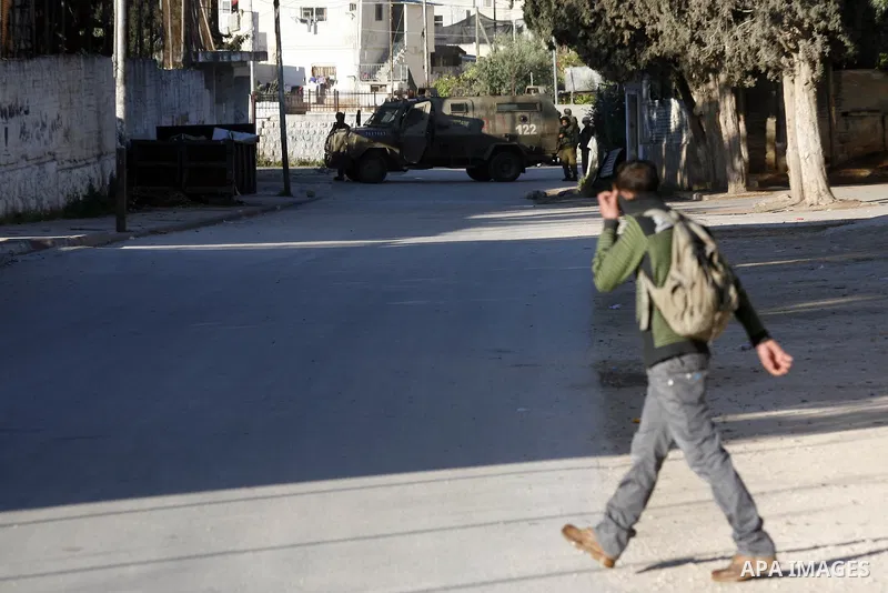 Palestinian youth throw stones towards Israeli soldiers patrolling near the shrine of Joseph's Tomb in the West Bank city of Nablus on April 24, 2011 as clashes erupted after an Israeli worshipper was shot dead by Palest...
